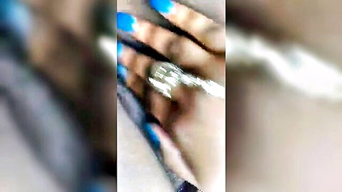 Blurry close-up of feminine hands with blue nail polish and silver ring