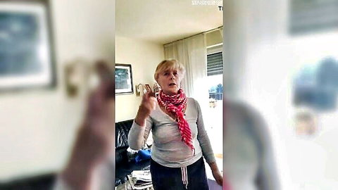 Blonde mature mother-in-law gesturing in red scarf and sweater