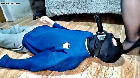 Mistress dominates slave with foot on dildo gag in BDSM femdom scene