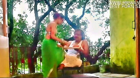 Sexy Indian woman in green skirt teases older man on outdoor balcony