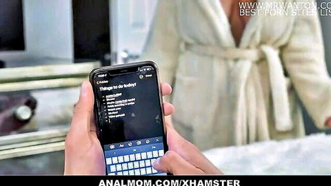 Curvy French MILF with huge tits exposing massive breasts in open white robe holding phone
