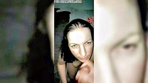 Topless woman with dark hair in close-up, hand touching face, cum facial tease