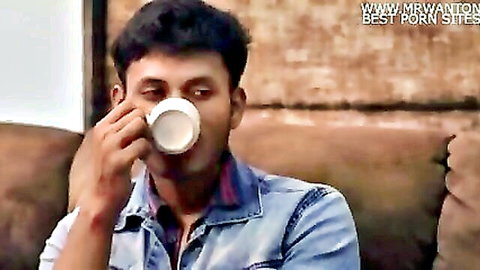 Indian man sipping tea from mug in checkered shirt, casual pose