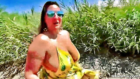 Busty mature woman in revealing yellow dress outdoors