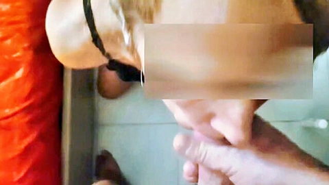 Amateur handjob closeup of fingers gripping hard cock near orange shorts on bathroom tiles