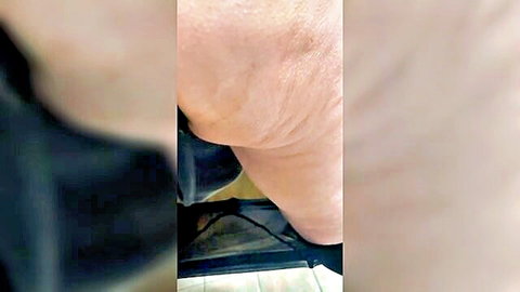 Blurry close-up of pale woman's exposed buttocks with black clothing pulled down