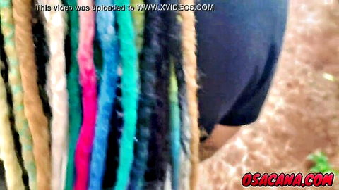 Amateur woman with colorful braids in black shorts, outdoor scene