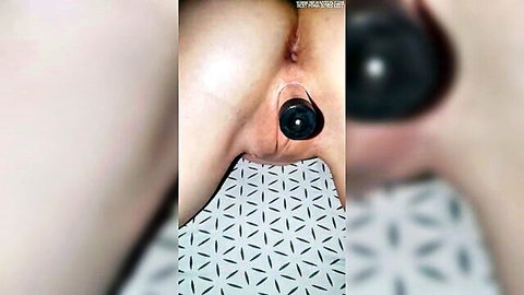 Closeup of woman's tight pink asshole stuffed with thick black butt plug