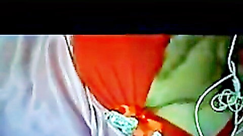 Busty Arab woman with massive tits spilling from orange red bra and green straps