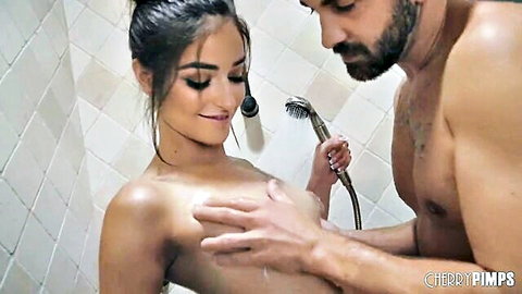 Muscular guy gropes skinny brunette's small natural tits in steamy shower