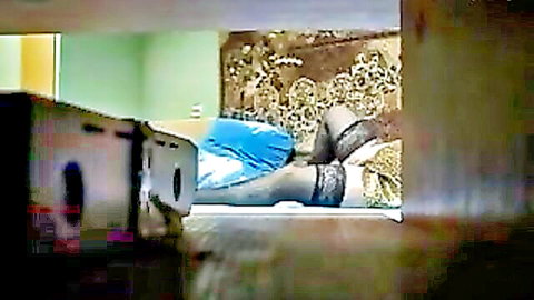 Latino in black stockings lounging seductively on bed