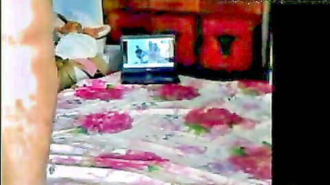 Desi Indian woman in CFNM setup watching laptop porn on floral bed