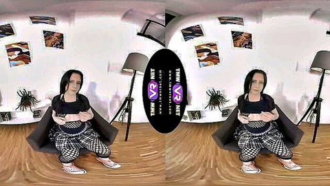 Caroline Mann in black top and plaid pants, sitting casually for TMWVRnet VR scene
