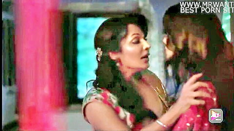 Two busty Indian women in colorful sarees intimately embracing and kissing passionately