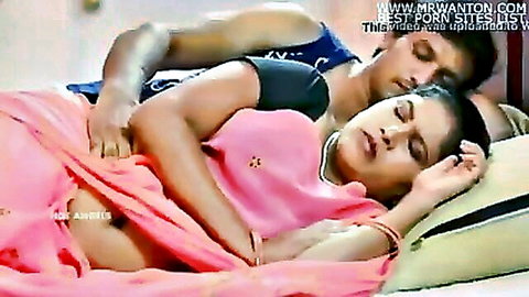 Indian couple intimately embracing in bed, woman in pink saree