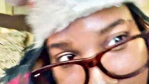 Ebony woman in sexy Santa hat and glasses close-up