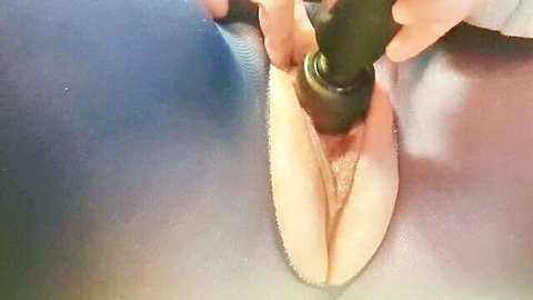Close-up of woman inserting black vibrator into pussy for convenient pleasure