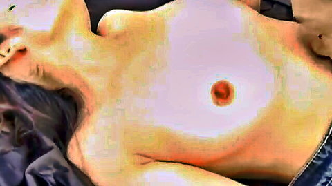 Topless Japanese woman lying down exposing her natural medium tits and erect pink nipple