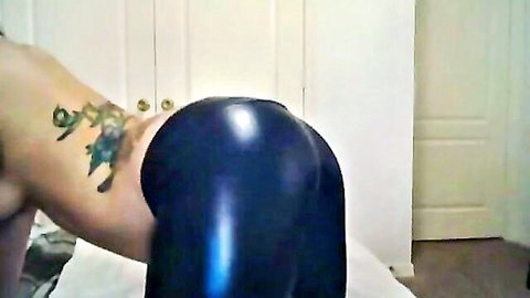 Tanned thick ass cheeks exposed from shiny blue leather pants pulled down with colorful tattoo on lower back