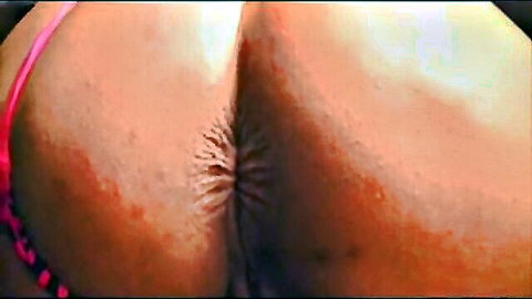 Close-up of curvy white woman's big ass in pink thong pulled aside, exposing anus