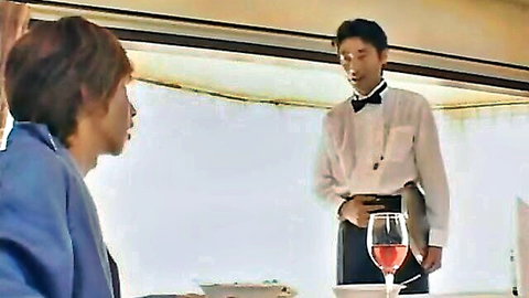 Asian waiter in bowtie uniform serving wine to suited man in JAV scene