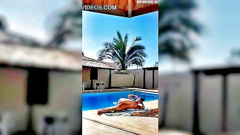 Sexy woman lounging nude by the pool, tan lines and curves