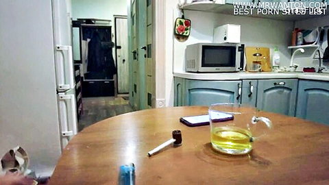 Empty kitchen table with yellow drink phone and pipe on wooden surface