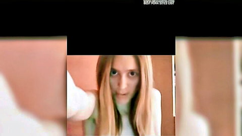 Surprised blonde woman in white top taking intense POV selfie closeup