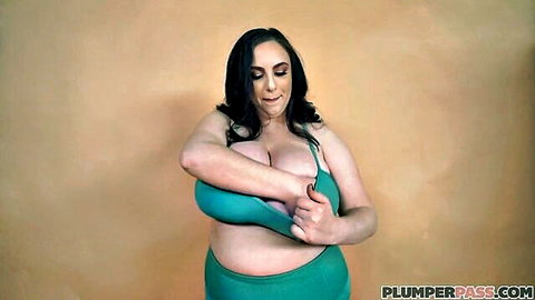 Curvy brunette BBW with massive tits adjusting green bikini top