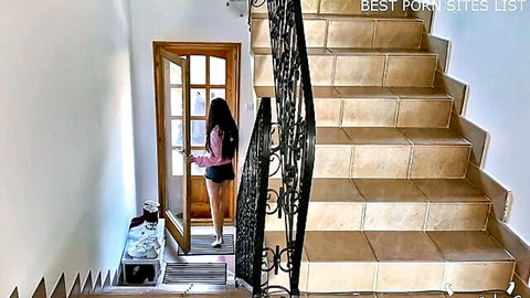 Skinny brunette babe in pink top and tiny white shorts teasing ass at hotel door