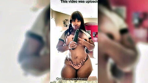 Curvy ebony MILF with huge tits and fat ass holds cucumber dildo between massive breasts