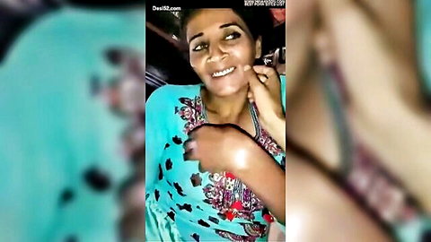 Mature Desi woman smiling in blue embroidered top, showing cleavage