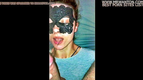 Masked brunette sticks out tongue to lick thick cock head closeup