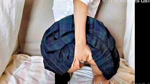 Japanese schoolgirl lifts plaid skirt and inserts black dildo into shaved pussy