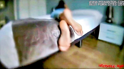 Mistress raises legs showing soles in femdom domination