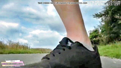 Slim woman's leg in black sneakers walking on rural path, public outdoor tease from Ultima