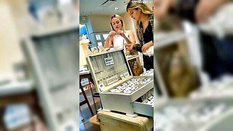 Tight blonde and brunette girlfriends examining jewelry in store