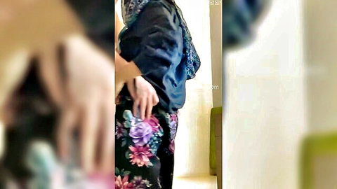 Muslim teen in floral skirt and scarf poses seductively sideways