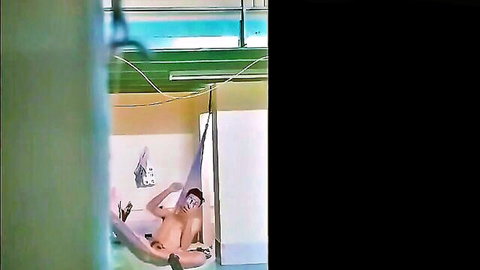 Nude Asian man lounging naked in hammock solo