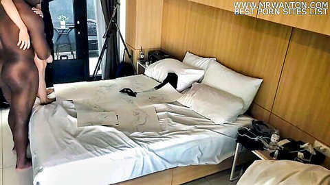 Petite East Asian woman bends over nude showing big ass and hairy pussy in bedroom