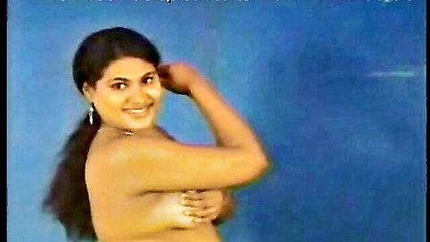 Smiling Indian woman in ponytail covering breasts in actress audition pose