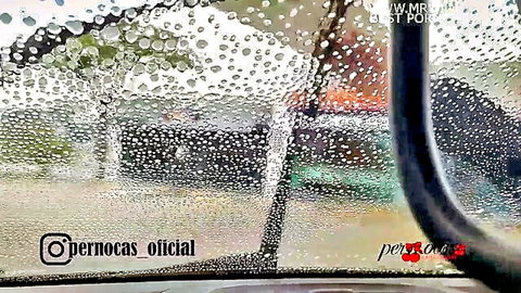 Raindrops covering blurry car window with @pernocas oficial watermark visible