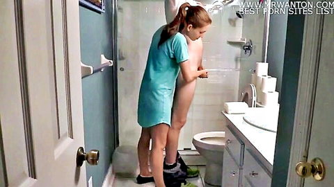 Amateur bathroom handjob with slim brunette in short teal dress