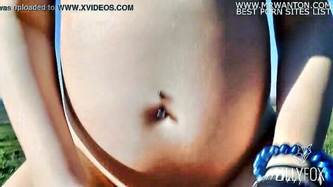 Pregnant teen's nude belly with piercing outdoors