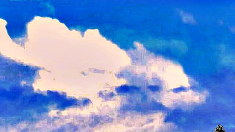 Fluffy white and pink clouds floating in vibrant blue sky
