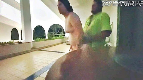 Camille naked outdoors as man grabs her hips in public elevator lobby