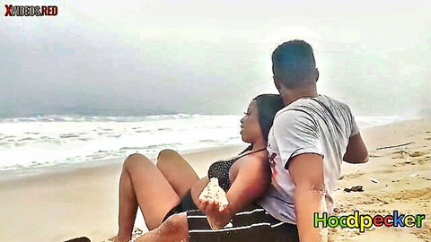 Ebony couple embracing on beach, woman in black bikini, romantic outdoor vibe