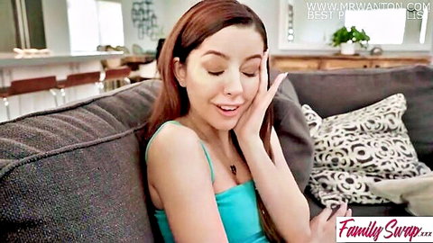 Brunette stepsis in blue tank top on couch, teasing Family Swap XXX scene