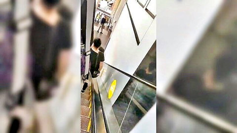 Blurry voyeur shot of sexy blonde office lady from behind on escalator