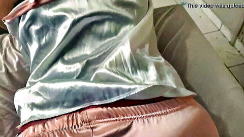 Amateur babe in shiny satin lingerie lying sideways on bed with tit spilling out